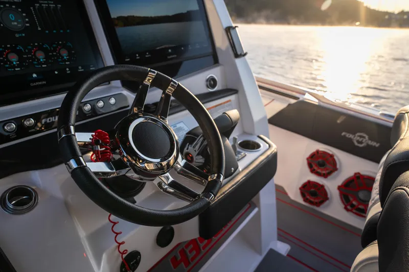 Slide: The Image of 2024 Fountain 43SCX boat cockpit with steering wheel and control panel at sunset. - 26