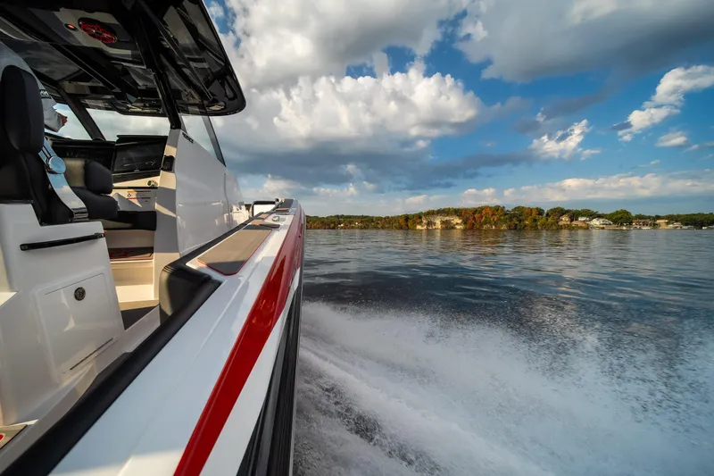 Slide: The Image of 2024 Fountain 43SCX boat cruising on a scenic lake under a partly cloudy sky. - 35