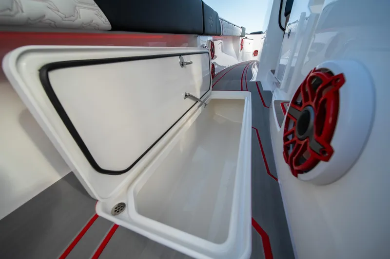 Slide: The Image of 2024 Fountain 43SCX boat interior with open storage compartment and red-accented speaker. - 38