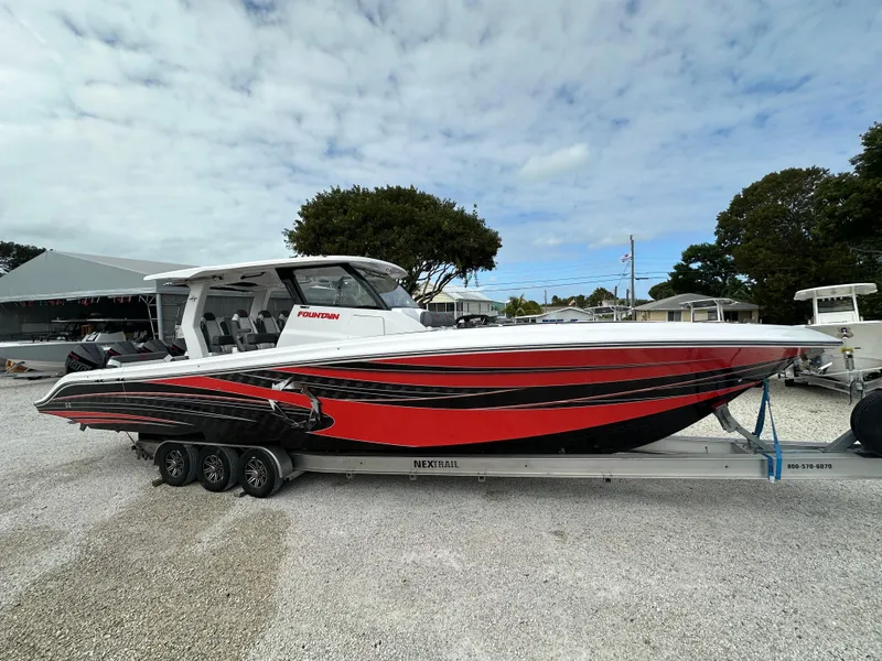 Slide: The Image of 2024 Fountain 43SCX boat with red and black design on a trailer. - 5