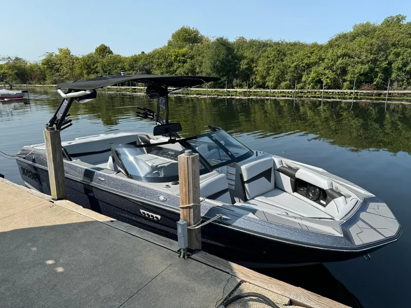 Slide: The Image of 2024 Supreme S220 boat docked on a calm lake. - 3