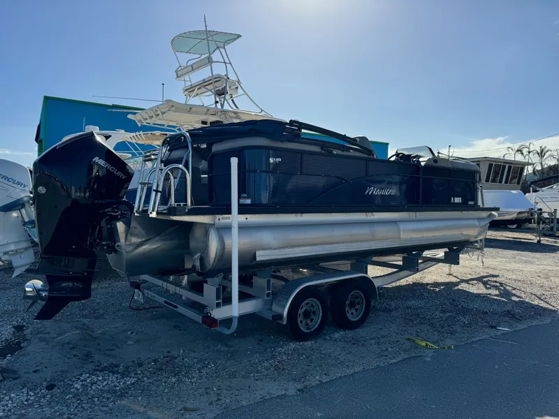 Slide: The Image of 2022 Manitou 23' Oasis RFSHP373 pontoon boat on trailer, parked outdoors. - 1