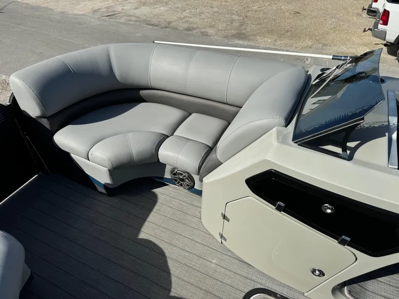 Slide: The Image of 2022 Manitou 23' Oasis RFSHP373 boat interior with gray seating and dashboard. - 10