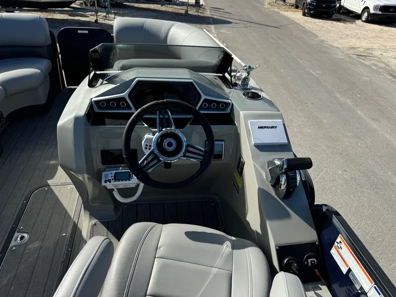 Slide: The Image of 2022 Manitou 23' Oasis RFSHP373 boat dashboard with steering wheel and controls. - 11
