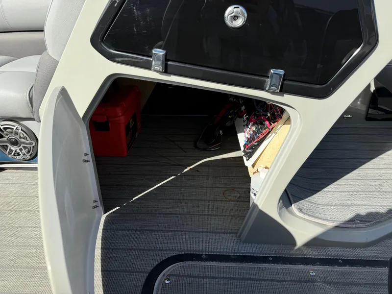 Slide: The Image of 2022 Manitou 23' Oasis RFSHP373 interior storage compartment with visible wiring and red toolbox. - 12