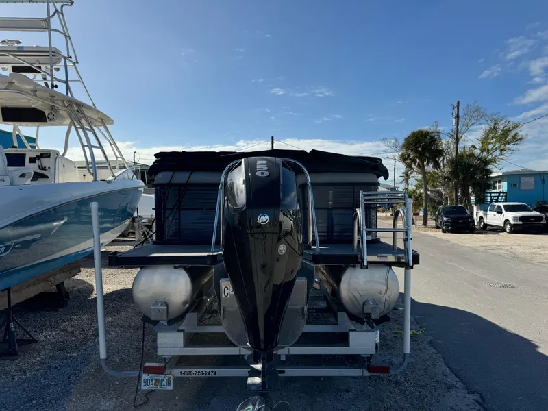Slide: The Image of 2022 Manitou 23' Oasis RFSHP373 pontoon boat with outboard motor, parked on a sunny day. - 3