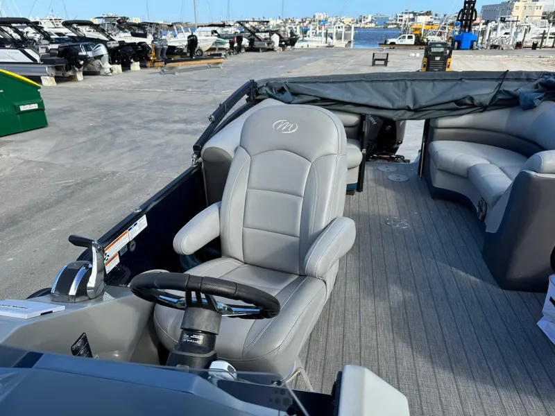 Slide: The Image of 2022 Manitou 23' Oasis RFSHP373 pontoon boat interior with gray seating and steering wheel. - 5