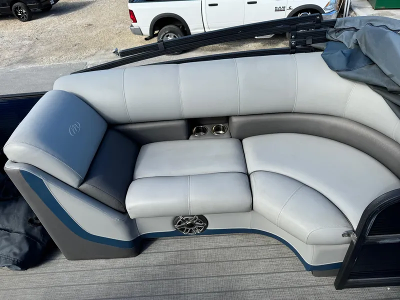 Slide: The Image of 2022 Manitou 23' Oasis RFSHP373 boat interior with gray seating and cup holders. - 7