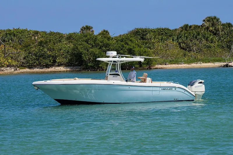 The Image of 2019 Century 3200 Center Console boat on calm water near lush shoreline. - 0