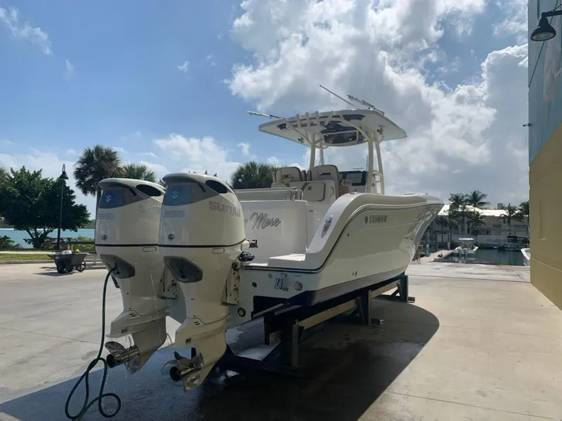 Slide: The Image of 2019 Century 3200 Center Console boat with twin outboard engines, docked outdoors. - 3