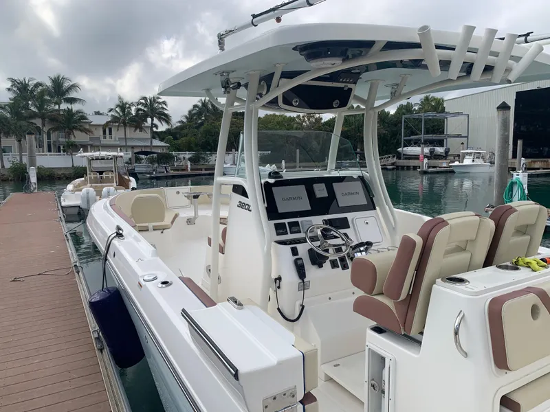 Slide: The Image of 2019 Century 3200 Center Console boat docked at marina, featuring modern helm and seating. - 8