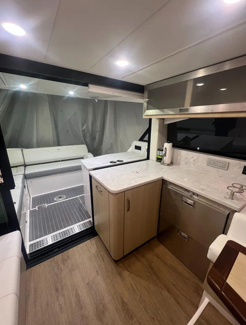 Slide: The Image of 2023 Regal 38 XO yacht interior with modern kitchen and sleek design. - 13