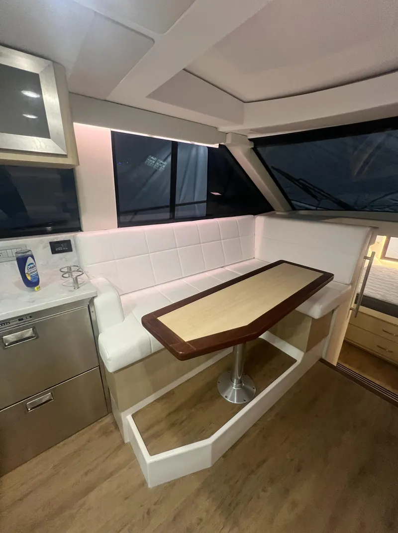 Slide: The Image of 2023 Regal 38 XO yacht interior with modern seating and dining area. - 16