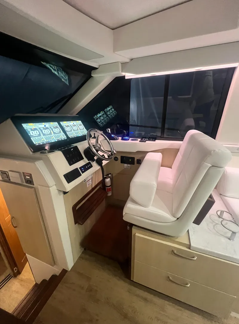 Slide: The Image of 2023 Regal 38 XO yacht helm with modern controls and plush seating. - 20