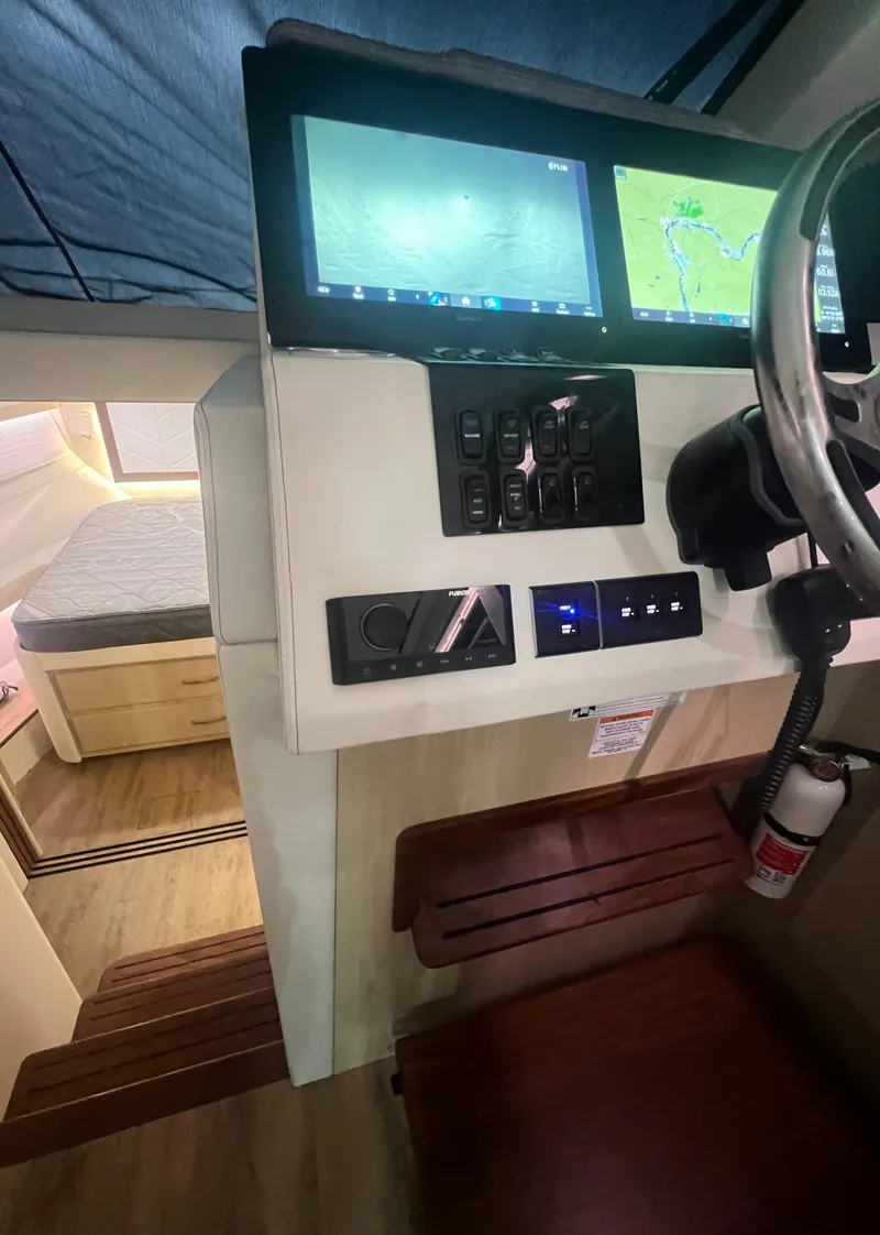Slide: The Image of 2023 Regal 38 XO helm with navigation screens and cozy cabin view. - 22