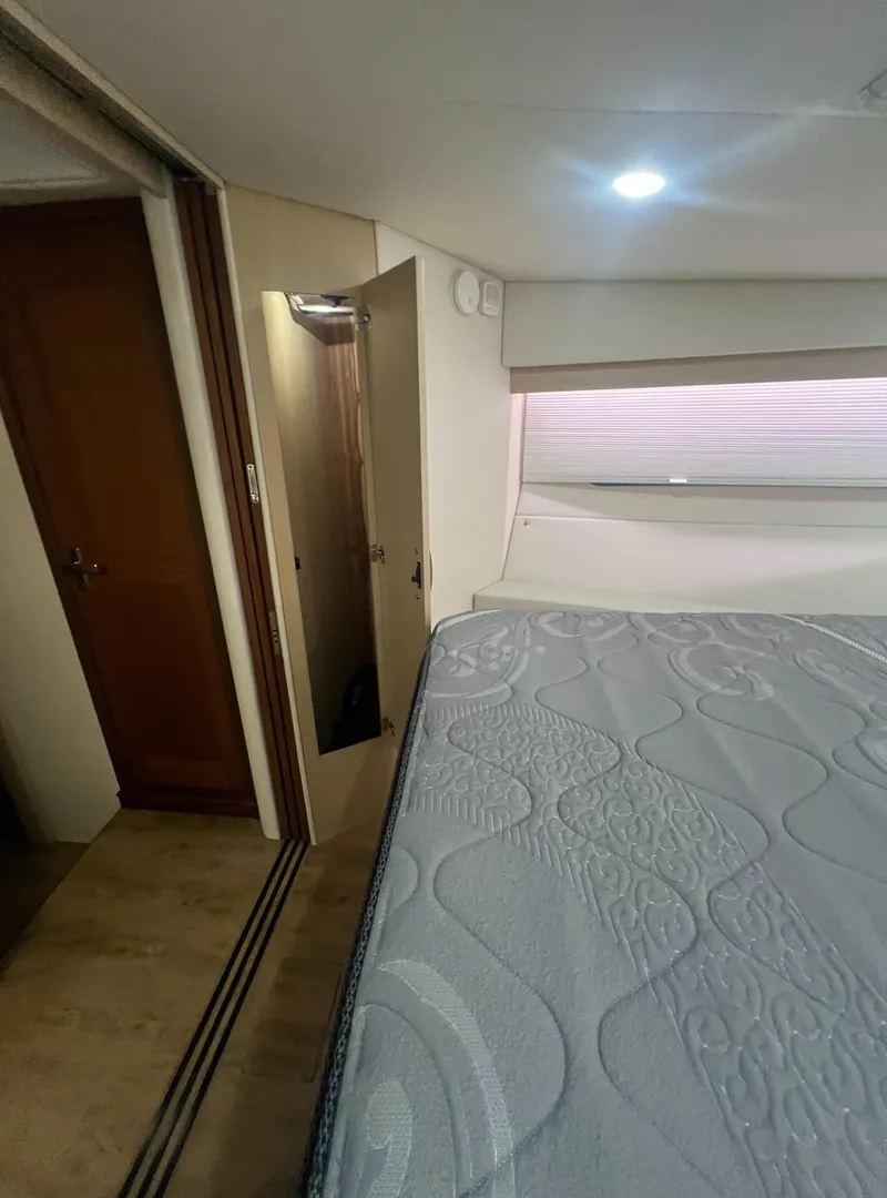 Slide: The Image of 2023 Regal 38 XO yacht interior bedroom with bed and window. - 29
