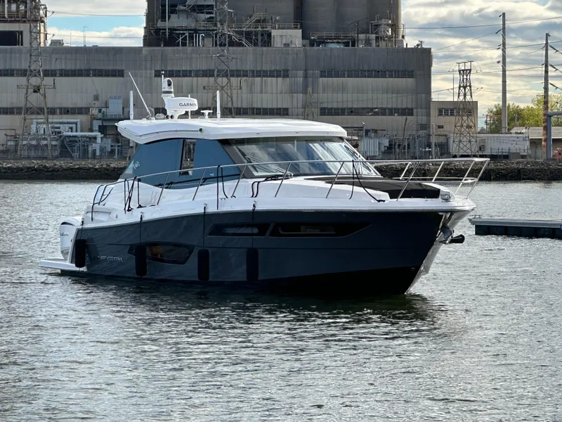 Slide: The Image of 2023 Regal 38 XO yacht on water near industrial backdrop. - 3
