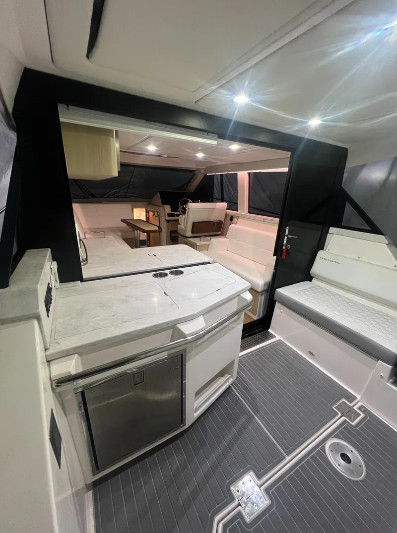 Slide: The Image of 2023 Regal 38 XO yacht interior with modern kitchen and seating area. - 6