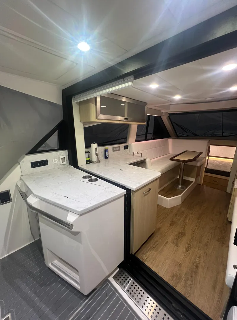Slide: The Image of 2023 Regal 38 XO yacht interior with modern kitchen and dining area. - 8