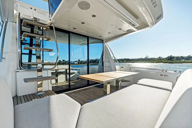 Slide: The Image of Luxurious 2019 Prestige 520 Fly yacht interior with seating and table, overlooking serene waters. - 14