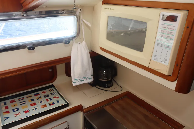 Slide: The Image of Legacy Boat Express 40 galley with microwave, coffee maker, and nautical flag tray, 1999 model. - 36