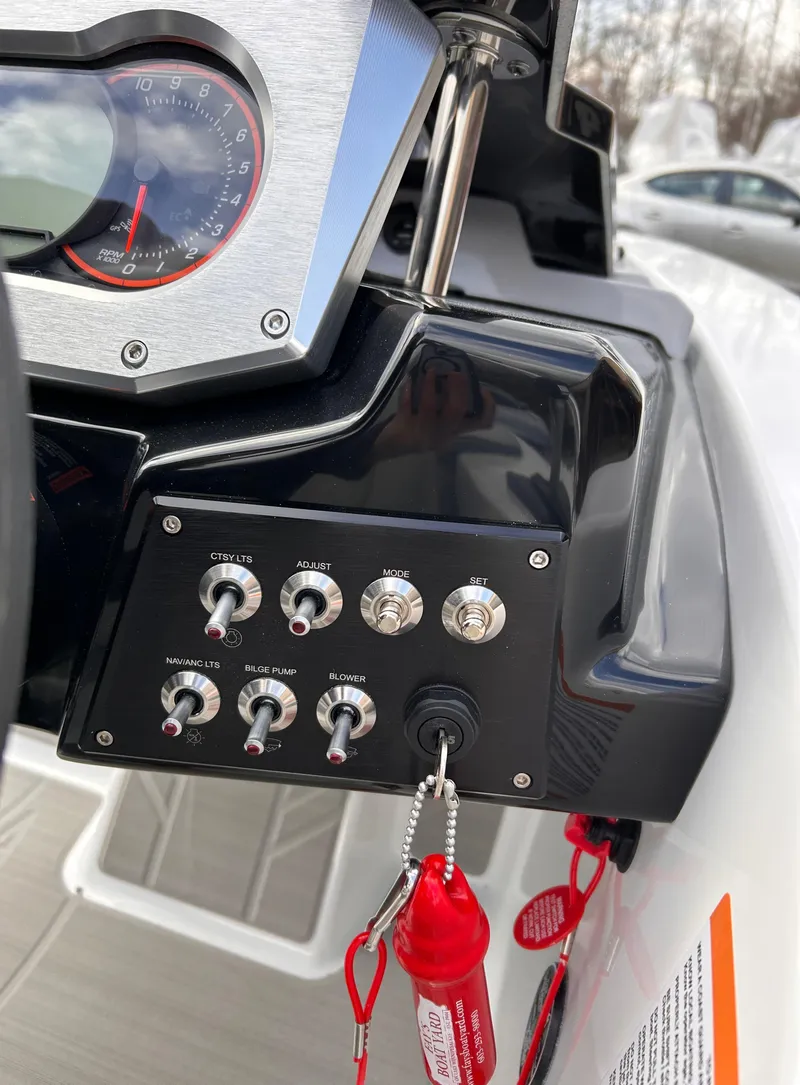 Slide: The Image of Control panel of 2025 Scarab 165 SE boat with switches and key. - 22