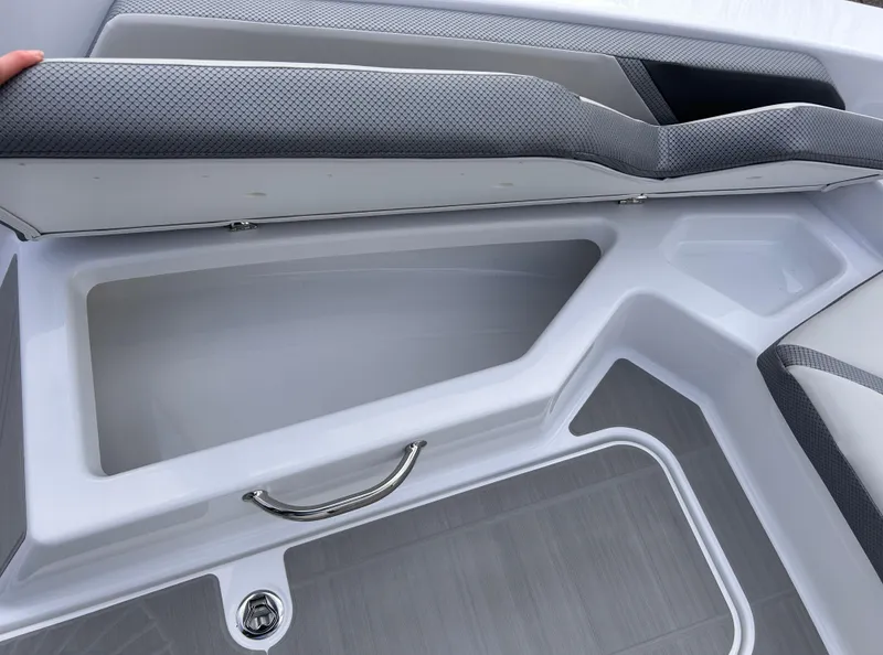 Slide: The Image of 2025 Scarab 165 SE boat storage compartment with gray cushioned seating. - 32