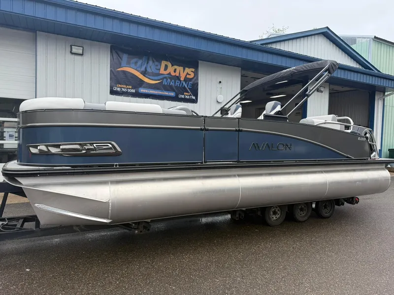 Slide: The Image of 2025 Avalon Catalina Quad Lounger Shift pontoon boat displayed at a marine dealership. - 4