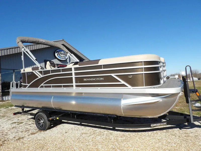 The Image of 2025 Bennington S Quad Bench 21 SSR pontoon boat on trailer, sunny day. - 1