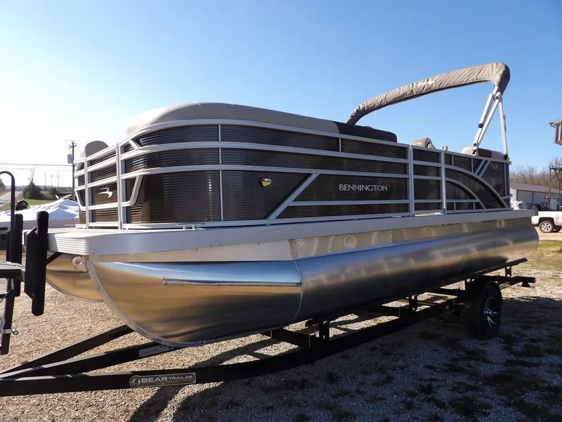 Slide: The Image of 2025 Bennington S Quad Bench 21 SSR pontoon boat on trailer, sunny day. - 3