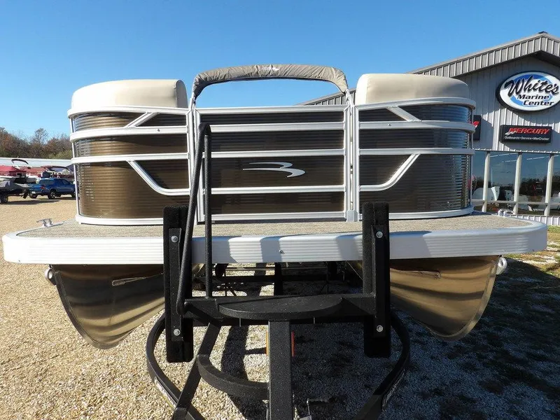 Slide: The Image of 2025 Bennington S Quad Bench 21 SSR pontoon boat on display at a marina. - 4
