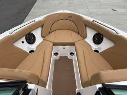 Slide: The Image of 2022 MasterCraft XT25 boat interior with tan seating and built-in speakers. - 10