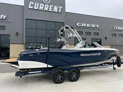 Slide: The Image of 2022 MasterCraft XT25 boat on trailer outside dealership. - 3