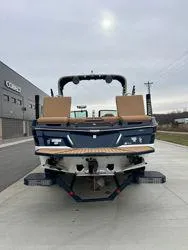 Slide: The Image of 2022 MasterCraft XT25 boat, rear view, parked on concrete near a building. - 4