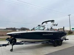 Slide: The Image of 2022 MasterCraft XT25 boat on trailer, parked outdoors. - 6