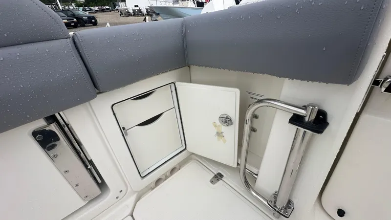 Slide: The Image of 2025 Boston Whaler 280 Outrage boat interior with storage compartment and wet seat cushions. - 11