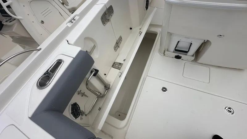 Slide: The Image of 2025 Boston Whaler 280 Outrage interior, showcasing storage compartment and seating area. - 14