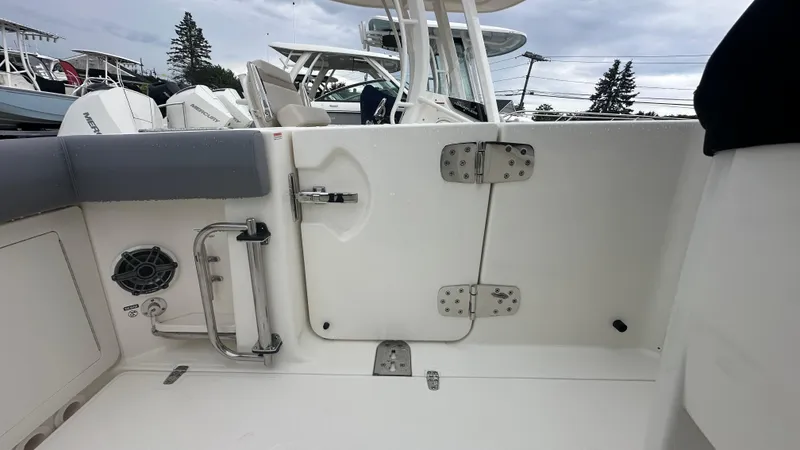 Slide: The Image of 2025 Boston Whaler 280 Outrage boat interior with seating and access door. - 15