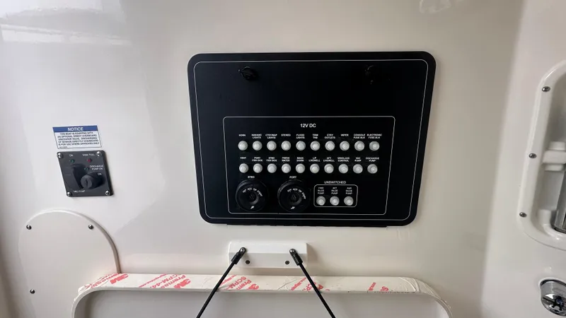 Slide: The Image of Control panel of 2025 Boston Whaler 280 Outrage boat, featuring various switches and dials. - 29