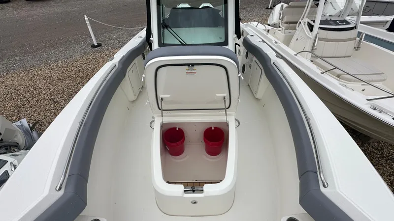 Slide: The Image of 2025 Boston Whaler 280 Outrage boat interior with open storage compartment and red buckets. - 31