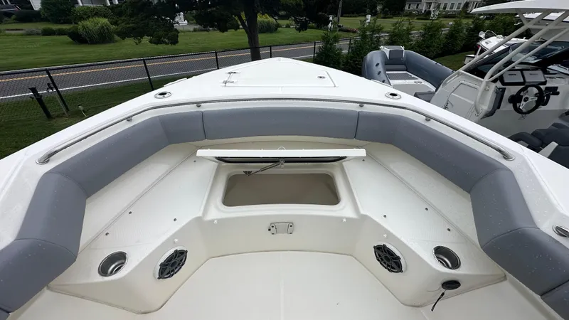 Slide: The Image of 2025 Boston Whaler 280 Outrage boat interior with cushioned seating and storage compartment. - 34