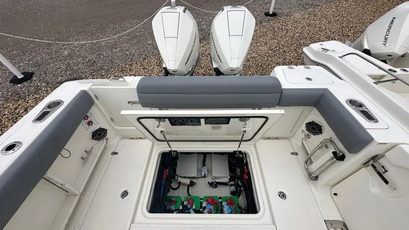 Slide: The Image of 2025 Boston Whaler 280 Outrage boat interior with open storage compartment and Mercury engines. - 9