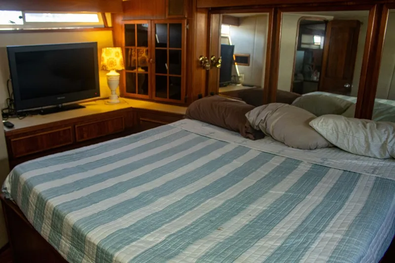 Slide: The Image of Luxurious bedroom interior of 1988 Chris-Craft 500 Constellation yacht with TV and striped bedding. - 21