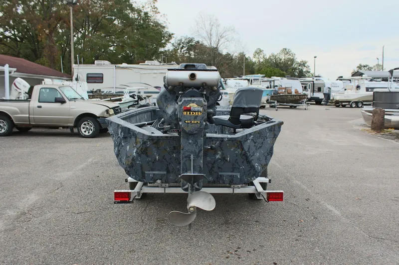 Slide: The Image of Excel Eclipse 1554 boat, 2025 model, parked in a lot with trailers and vehicles. - 10