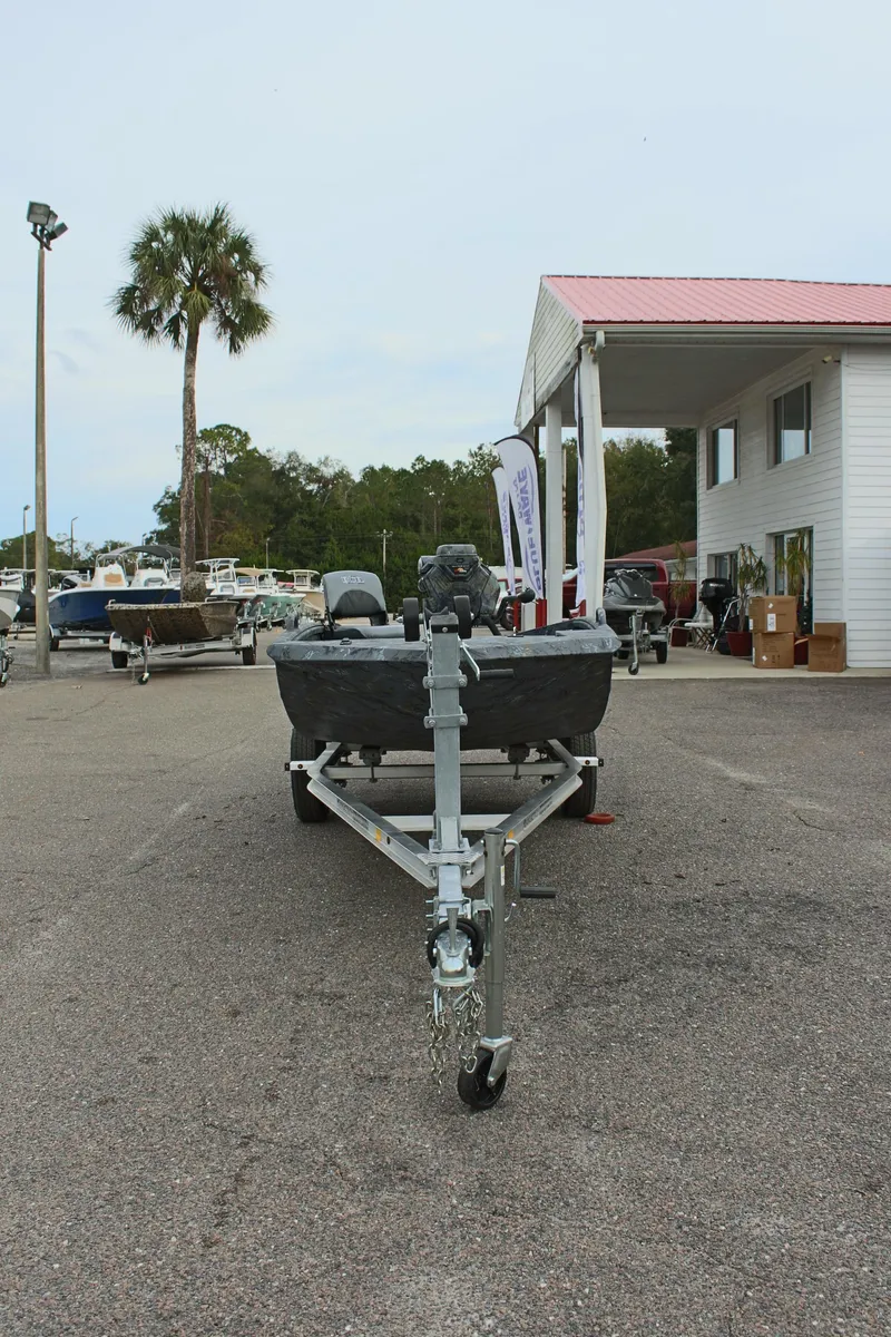 Slide: The Image of 2025 Excel Eclipse 1554 boat on trailer at dealership, palm tree in background. - 6