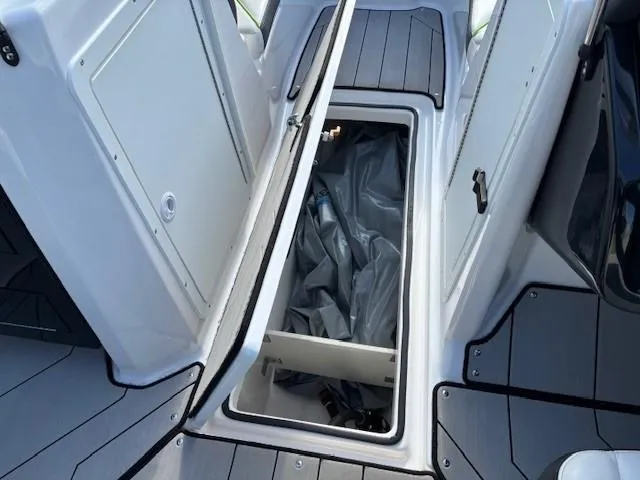 Slide: The Image of 2021 Yamaha Boats 212XE storage compartment with open hatch, showcasing interior space. - 12