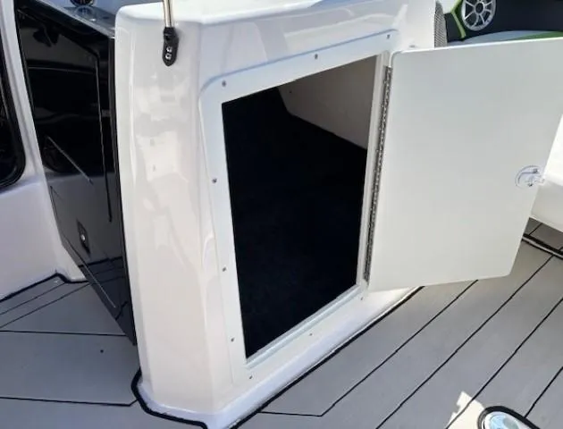 Slide: The Image of Open storage compartment on 2021 Yamaha Boats 212XE deck. - 13