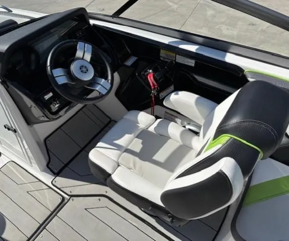 Slide: The Image of 2021 Yamaha Boats 212XE cockpit with steering wheel and comfortable seating. - 18