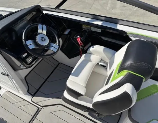 Slide: The Image of 2021 Yamaha Boats 212XE cockpit with steering wheel and seating. - 19