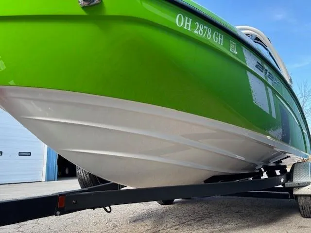 Slide: The Image of 2021 Yamaha Boats 212XE in vibrant green on trailer, side view. - 2